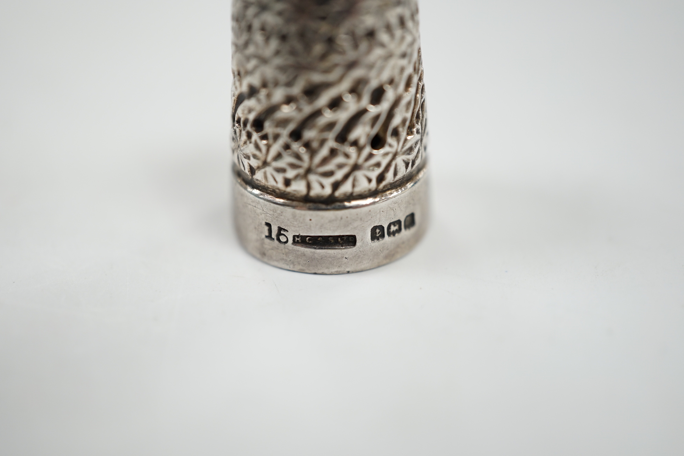 A George V silver thimble, a later silver brooch, a white metal, marcasite and black onyx brooch and one other brooch.